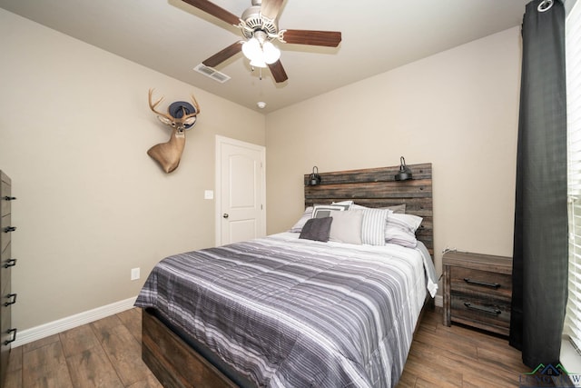 bedroom featuring a ceiling fan, baseboards, visible vents, and wood finished floors