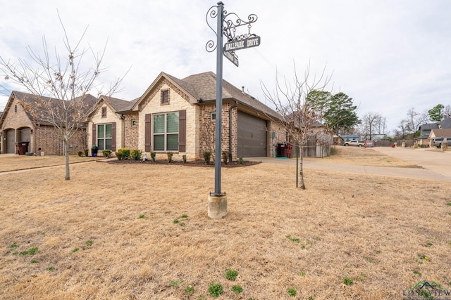 ranch-style home featuring a garage, concrete driveway, brick siding, and a front yard