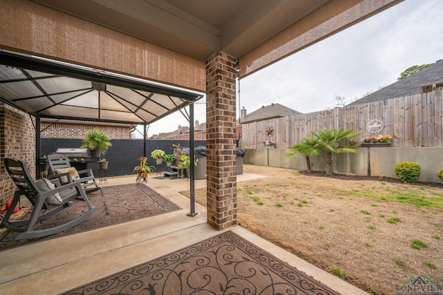 view of patio / terrace featuring a fenced backyard, grilling area, and a gazebo