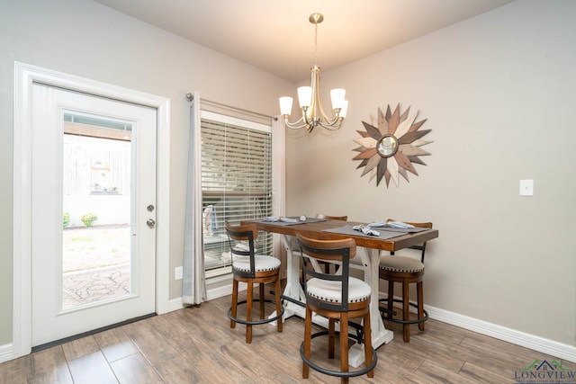 dining room with an inviting chandelier, baseboards, and wood finished floors