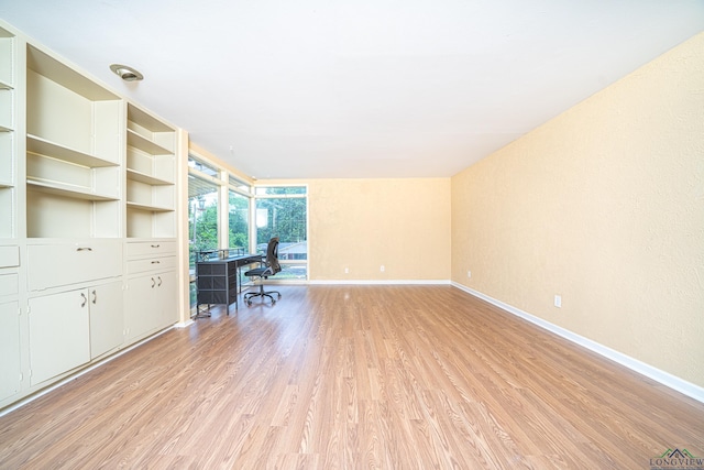 unfurnished office with built in features and light hardwood / wood-style floors