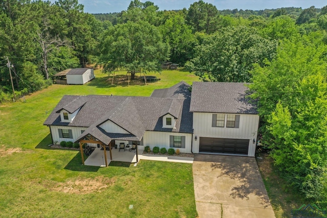223 Circle Ridge Dr, Gilmer, TX 75645 - view of front of property with board and batten siding, driveway, an attached garage, and a front yard