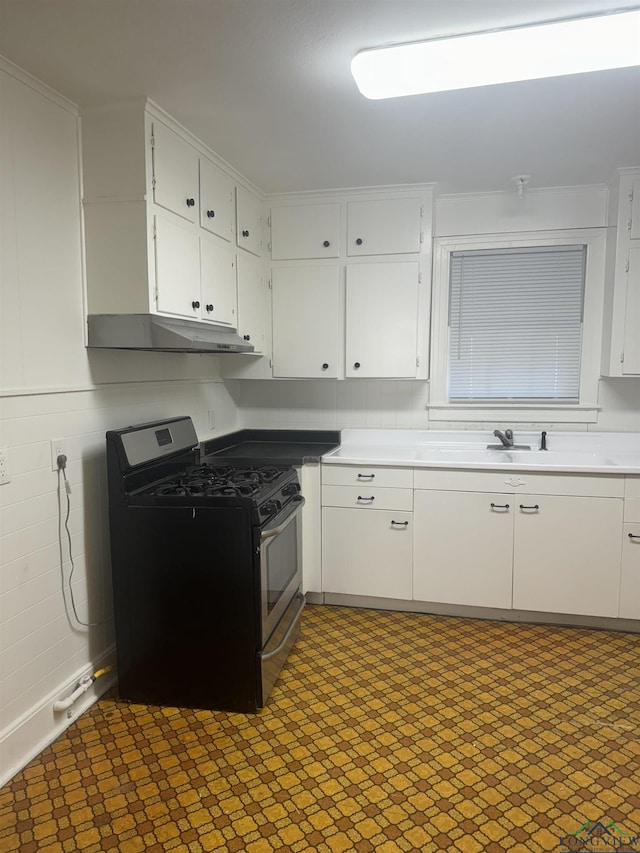 kitchen with black gas stove, white cabinets, and sink