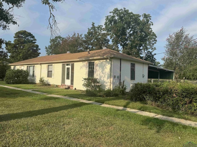 single story home with a front lawn and a carport