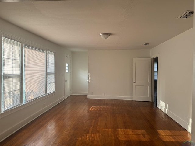 empty room featuring dark hardwood / wood-style flooring and plenty of natural light