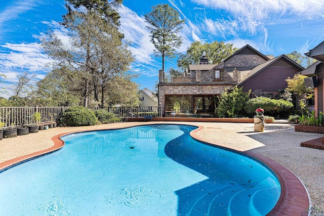 view of swimming pool featuring fence, a fenced in pool, and a patio