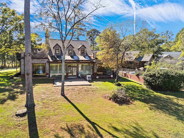 view of front facade featuring a patio, a front lawn, and fence