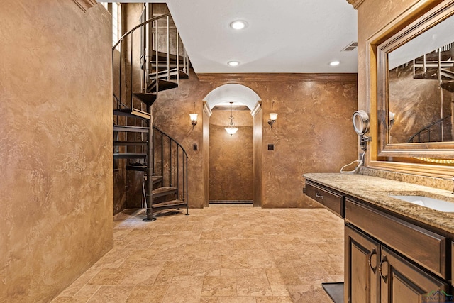 wine area featuring visible vents, arched walkways, stone finish flooring, a sink, and recessed lighting