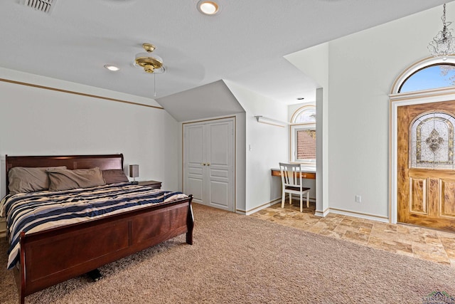 bedroom with lofted ceiling, light colored carpet, visible vents, stone finish floor, and baseboards