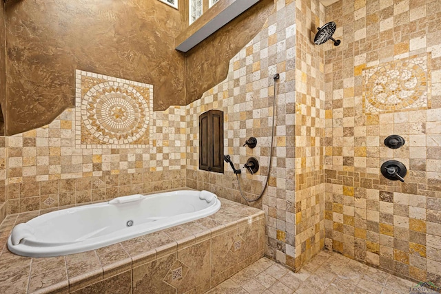 bathroom with tiled tub and a tile shower