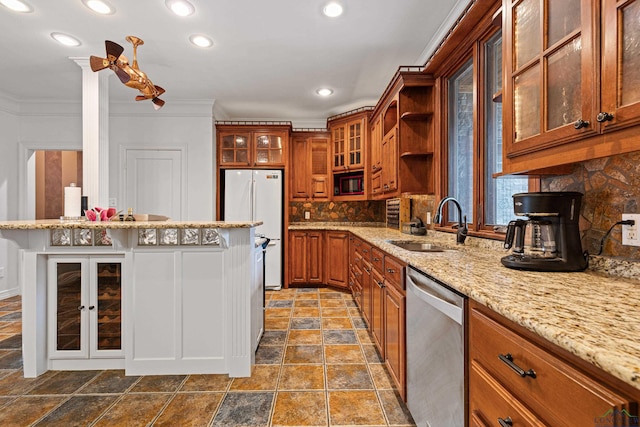 kitchen with a sink, stainless steel dishwasher, freestanding refrigerator, brown cabinets, and glass insert cabinets