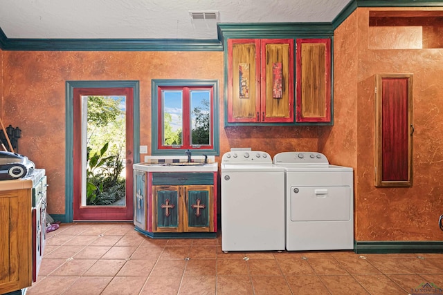 laundry room with light tile patterned floors, washing machine and dryer, a sink, ornamental molding, and cabinet space