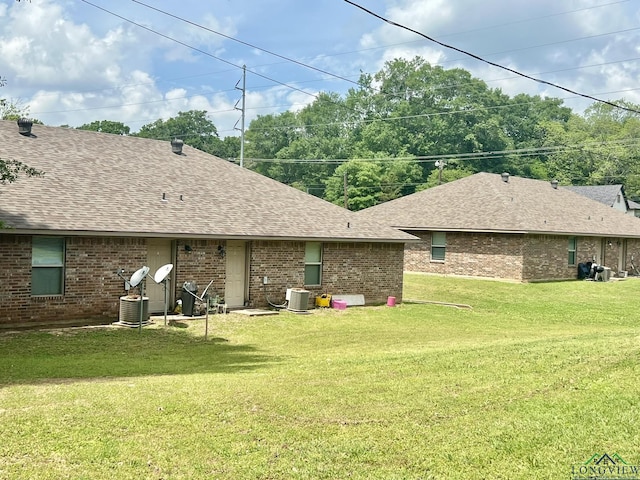 back of house with a lawn and central air condition unit