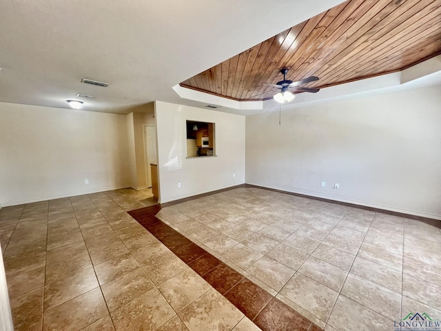 spare room with a tray ceiling, ceiling fan, and wooden ceiling