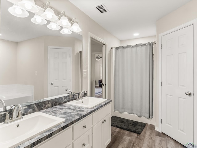 bathroom with a bath, visible vents, and a sink