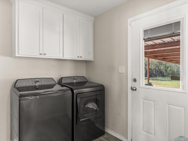 laundry area with baseboards, cabinet space, independent washer and dryer, and wood finished floors