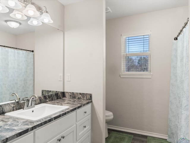 full bath with toilet, vanity, baseboards, and wood finished floors