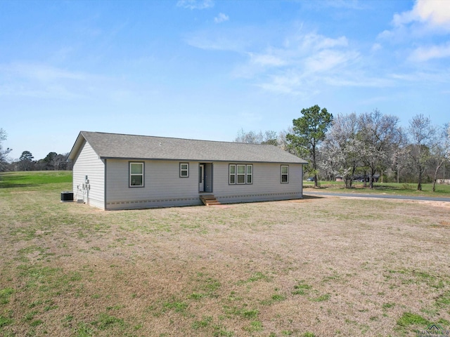 ranch-style home featuring roof with shingles and a front yard