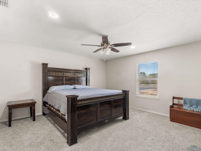 bedroom with a ceiling fan, light colored carpet, visible vents, and baseboards