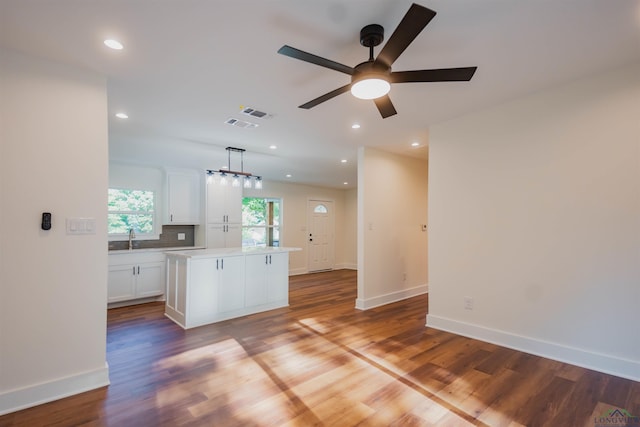 109 Montie St, Longview, TX 75604 - kitchen with a center island, white cabinetry, light countertops, and wood finished floors
