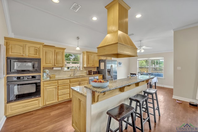 801 NW Dr, Longview, TX 75604 - kitchen with black appliances, a breakfast bar area, light brown cabinetry, healthy amount of natural light, and crown molding