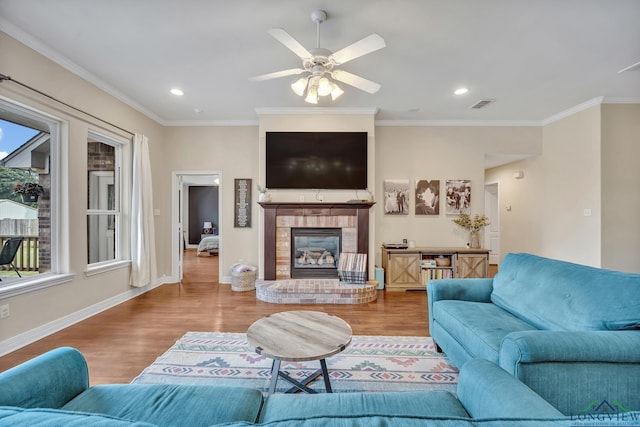 801 NW Dr, Longview, TX 75604 - living room with wood finished floors, ornamental molding, plenty of natural light, a glass covered fireplace, and ceiling fan