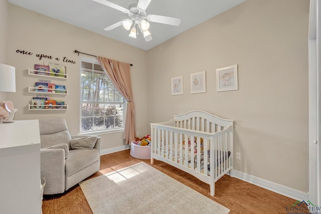801 NW Dr, Longview, TX 75604 - bedroom with a crib, wood finished floors, and a ceiling fan