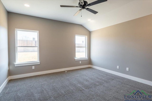 carpeted empty room with lofted ceiling, ceiling fan, and a healthy amount of sunlight