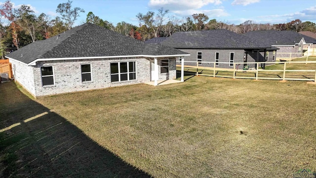 back of property featuring central AC unit and a yard