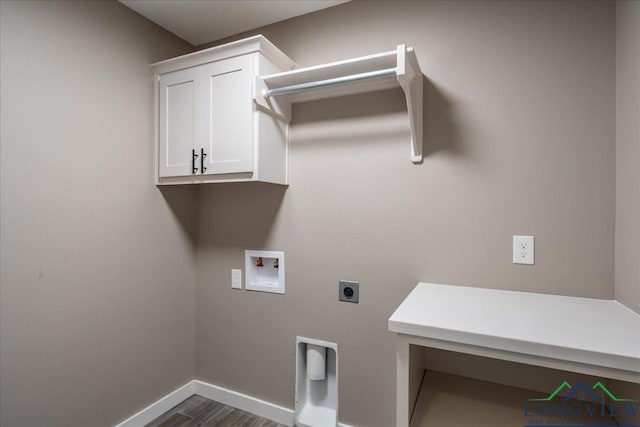 laundry area featuring dark wood-type flooring, hookup for an electric dryer, hookup for a washing machine, and cabinets