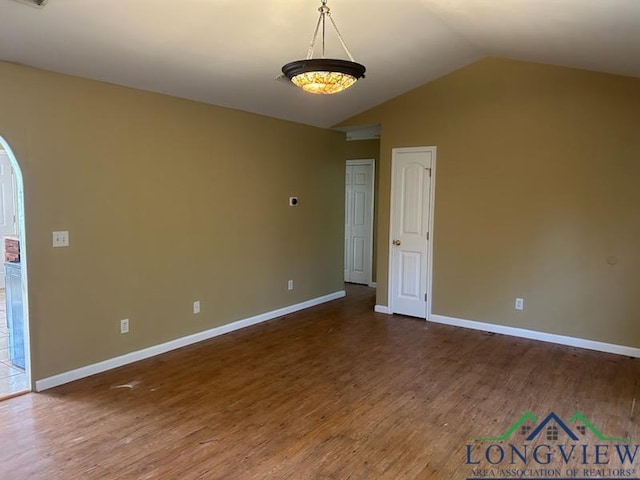 42 Wingwood Ter, Marshall, TX 75670 - empty room featuring wood finished floors, lofted ceiling, and arched walkways