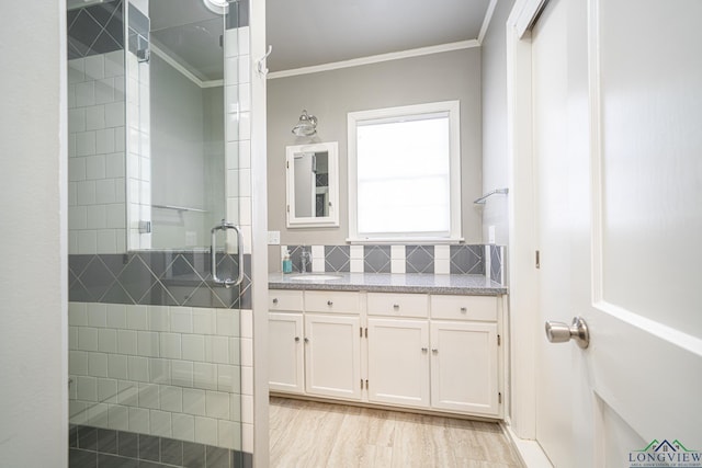 bathroom featuring decorative backsplash, crown molding, vanity, and walk in shower