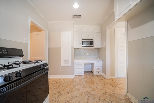 kitchen featuring tasteful backsplash, ornamental molding, black gas range oven, white cabinets, and stainless steel microwave