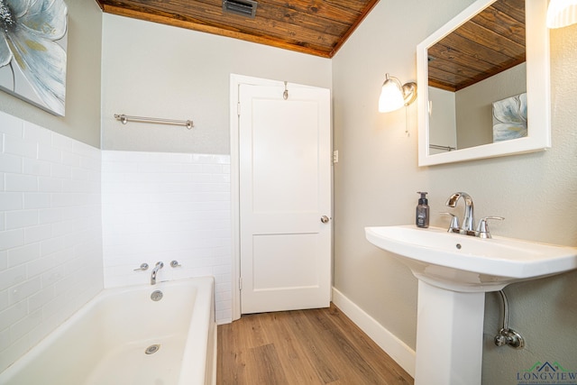 bathroom featuring a tub to relax in, ornamental molding, wood ceiling, and wood-type flooring