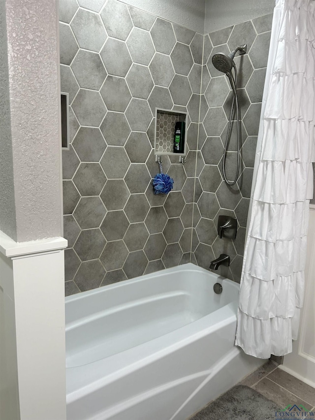 bathroom featuring shower / bath combo with shower curtain and tile patterned flooring