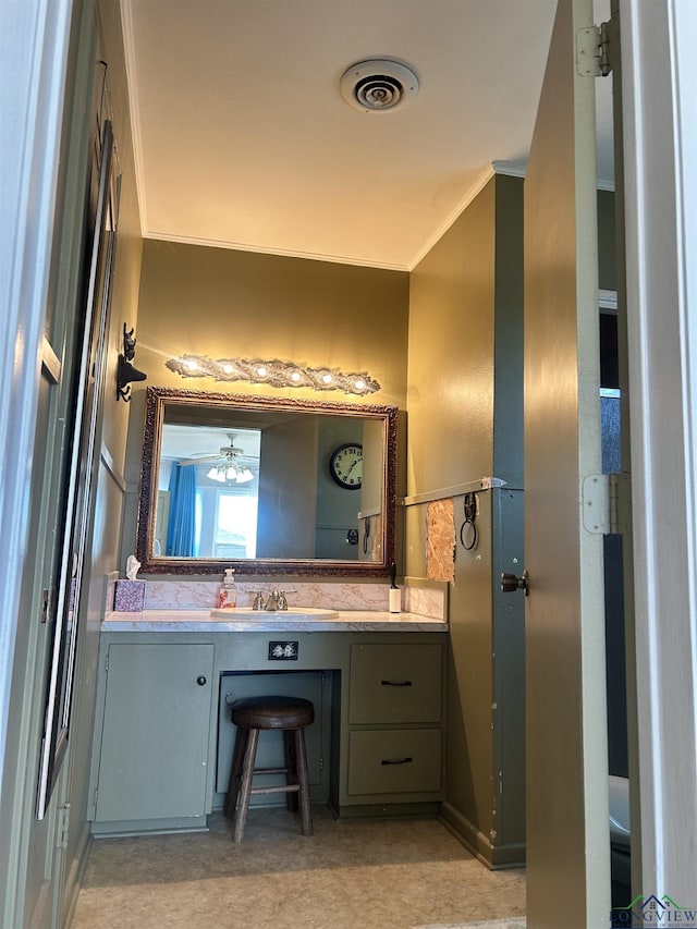 bathroom with ceiling fan, vanity, and ornamental molding