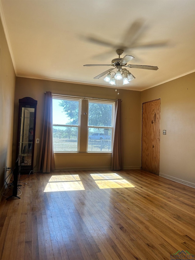 empty room featuring hardwood / wood-style flooring, ceiling fan, and ornamental molding