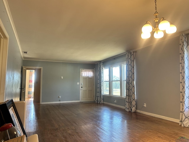 foyer entrance featuring dark hardwood / wood-style floors, crown molding, and a notable chandelier