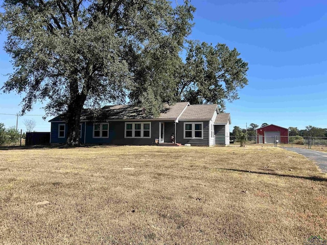 ranch-style house with a front yard and an outdoor structure