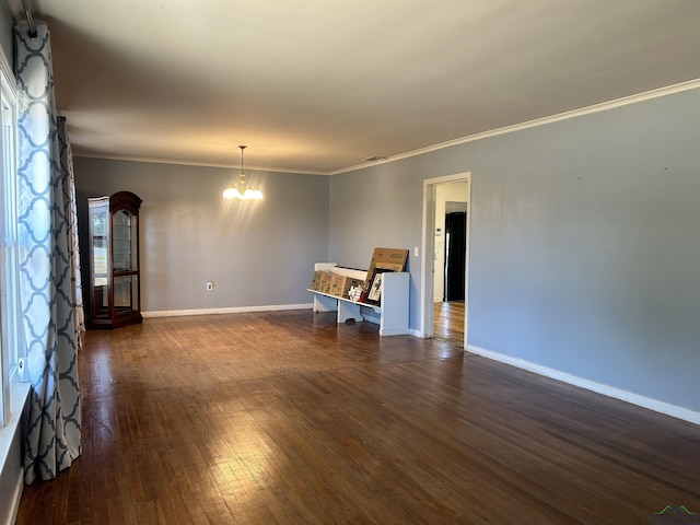 unfurnished room featuring crown molding, dark wood-type flooring, and an inviting chandelier