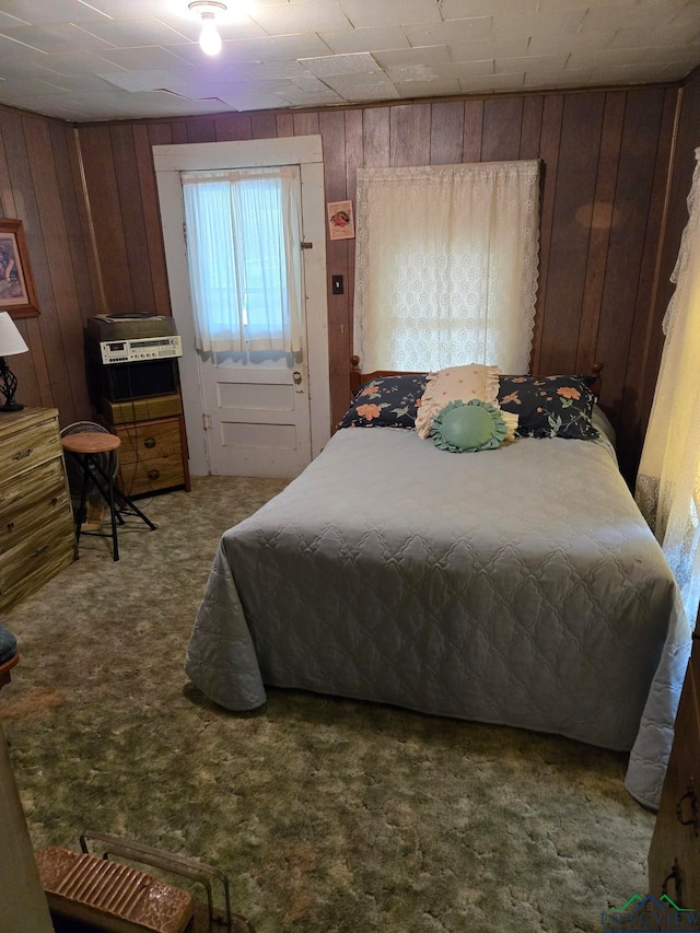 carpeted bedroom with wooden walls