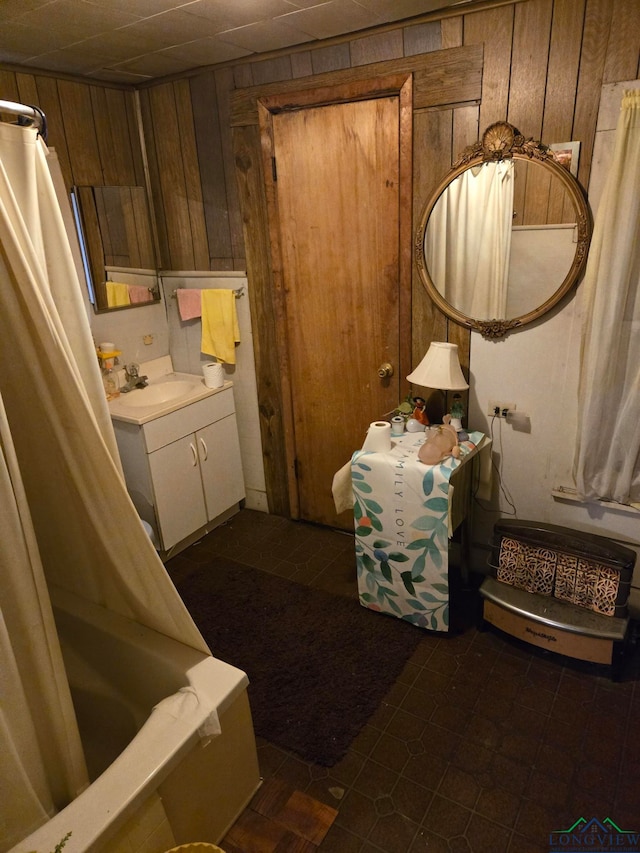 bathroom featuring vanity, wooden walls, and shower / bath combo with shower curtain