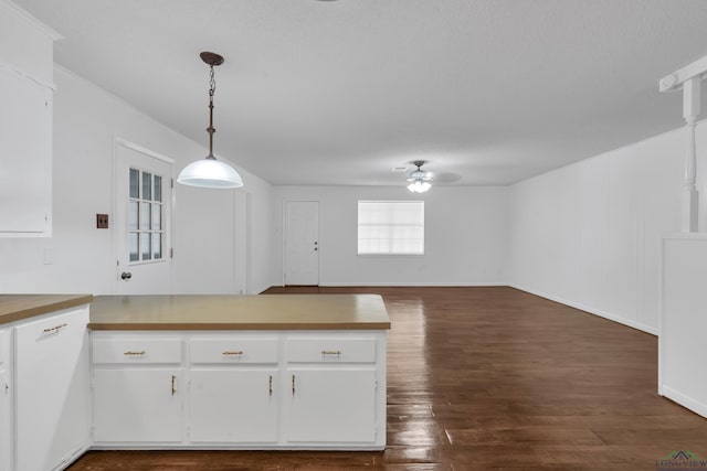 kitchen featuring white cabinets, decorative light fixtures, ceiling fan, and dark hardwood / wood-style flooring