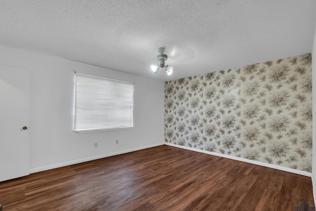 empty room featuring a textured ceiling and dark hardwood / wood-style floors