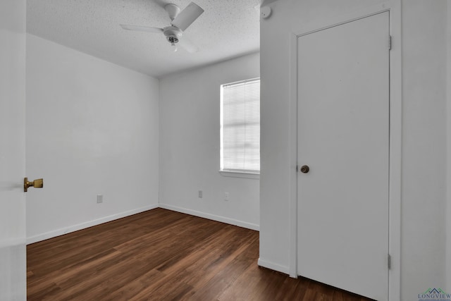 unfurnished bedroom with a textured ceiling, dark hardwood / wood-style floors, and ceiling fan