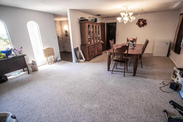 dining space with a chandelier and light colored carpet