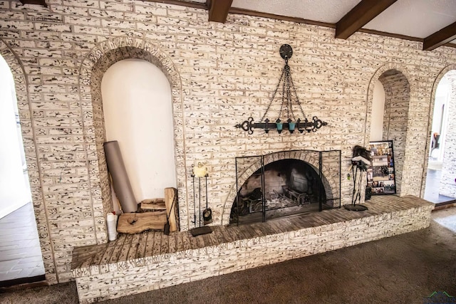 interior space featuring beamed ceiling, hardwood / wood-style flooring, and a brick fireplace