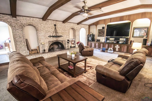 carpeted living room featuring vaulted ceiling with beams, ceiling fan, and a fireplace