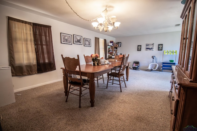 carpeted dining area with a chandelier