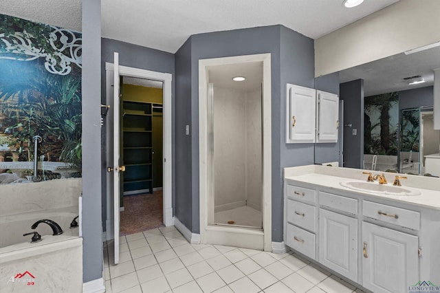 full bathroom with tile patterned flooring, vanity, a spacious closet, a shower stall, and a bath